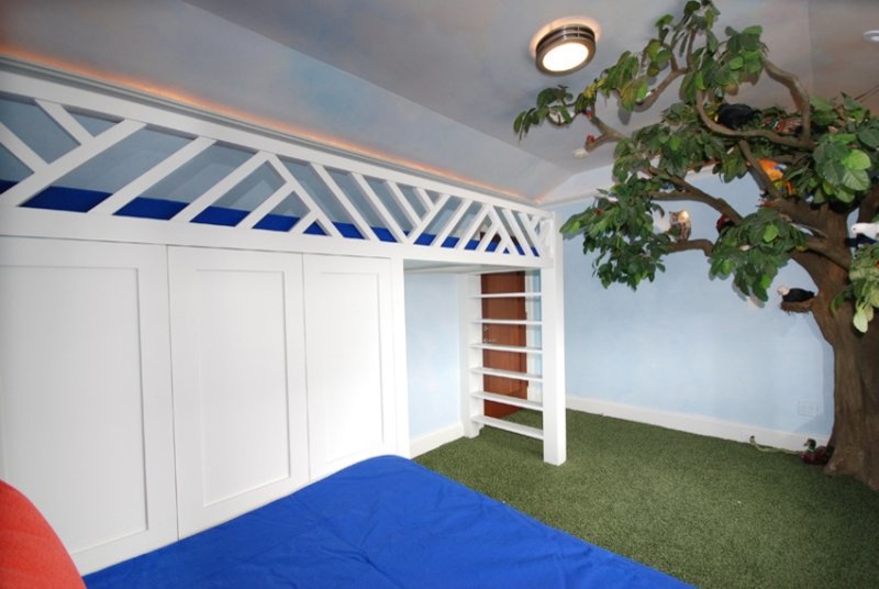 Large contemporary gender-neutral kids' bedroom in New York with blue walls and carpet for kids 4-10 years old.
