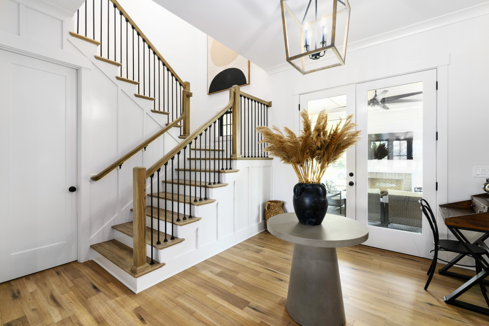 Photo of a mid-sized country wood u-shaped staircase in Jacksonville with painted wood risers, metal railing and panelled walls.