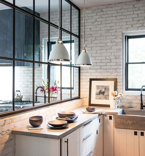 Photo of a mid-sized contemporary l-shaped kitchen in Portland with a farmhouse sink, flat-panel cabinets, white cabinets, concrete benchtops, white splashback, brick splashback and grey benchtop.