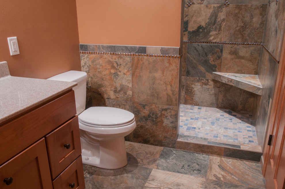 Photo of a mid-sized contemporary master bathroom in Other with shaker cabinets, dark wood cabinets, a corner shower, brown tile, ceramic tile, brown walls and an undermount sink.