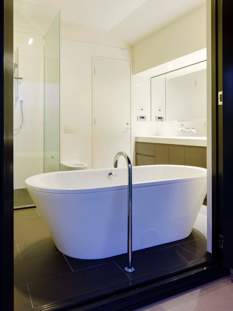 Inspiration for a large contemporary master bathroom in Melbourne with an undermount sink, flat-panel cabinets, black cabinets, marble benchtops, a freestanding tub, an open shower, a wall-mount toilet, ceramic tile, white walls, ceramic floors and black and white tile.