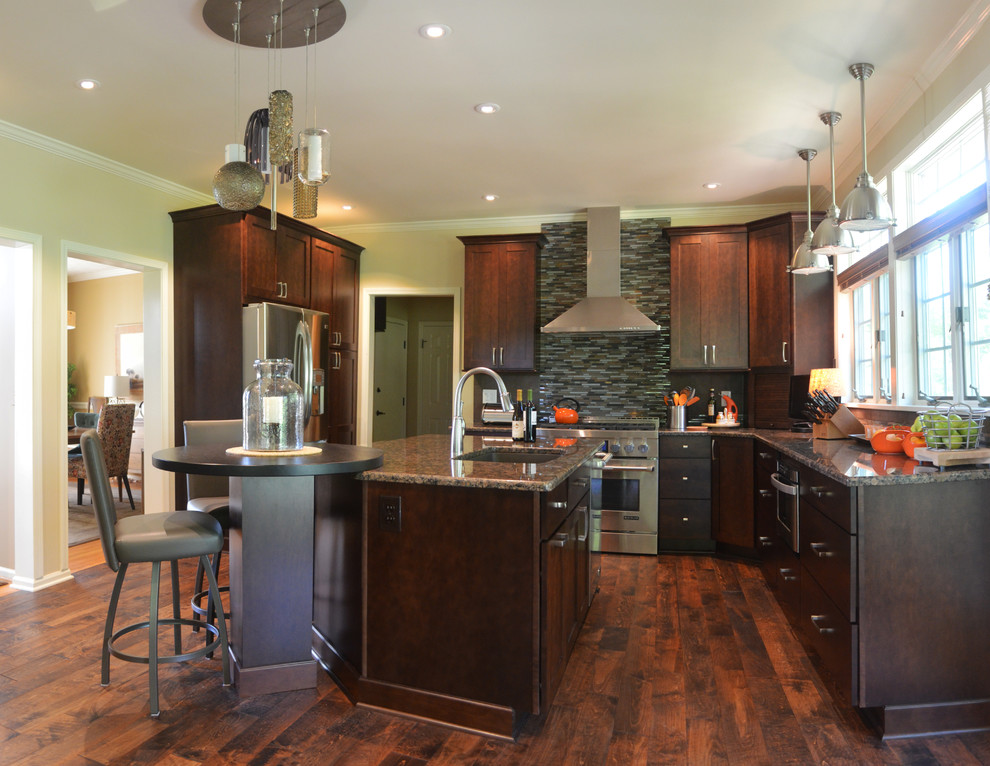 Inspiration for a large transitional u-shaped medium tone wood floor kitchen remodel with an undermount sink, shaker cabinets, brown cabinets, granite countertops, stainless steel appliances and an island