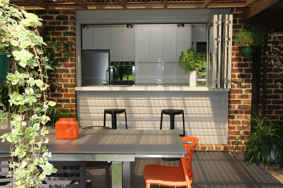 This is an example of a large contemporary side yard patio in Sydney with an outdoor kitchen and a pergola.