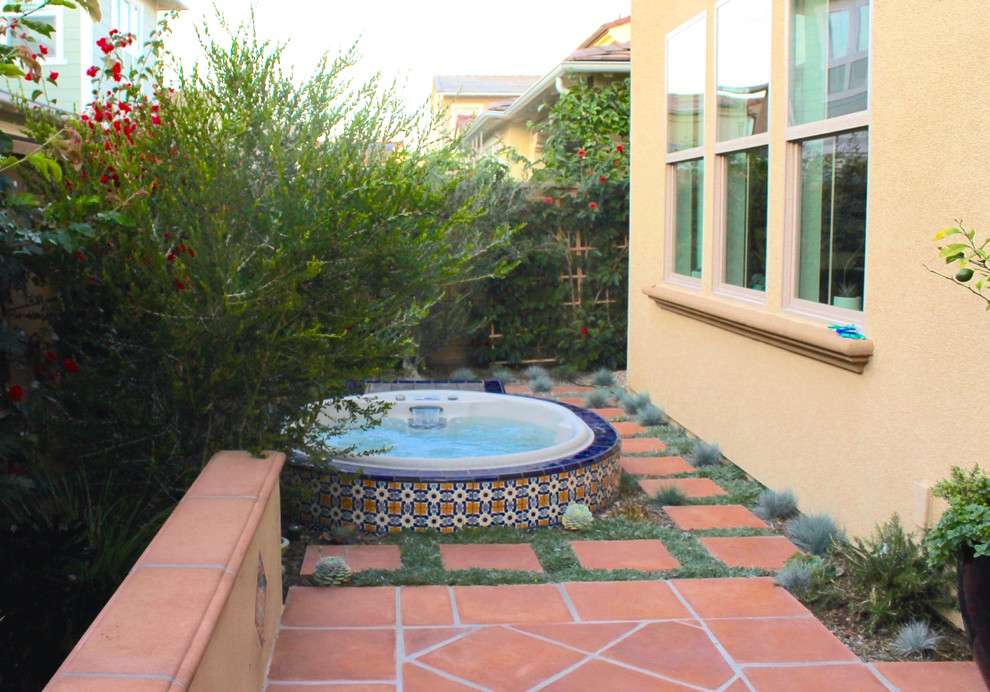 Inspiration for a mid-sized contemporary backyard full sun xeriscape in Orange County with a water feature.