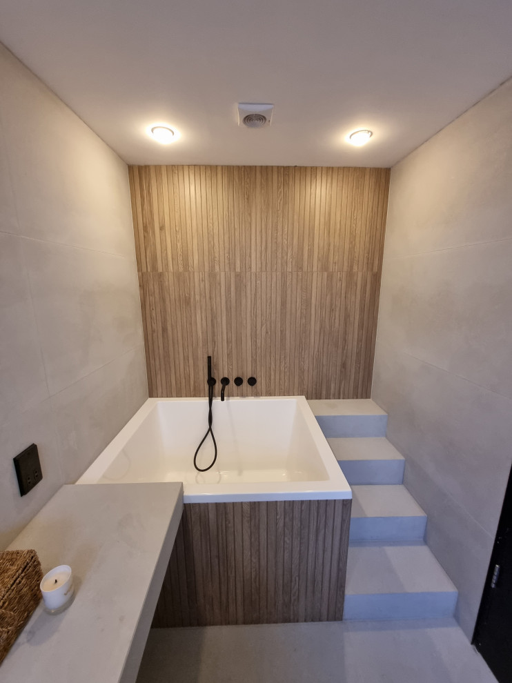 Photo of a scandinavian master bathroom in Other with white cabinets, a japanese tub, an open shower, a wall-mount toilet, white tile, porcelain tile, white walls, porcelain floors, a vessel sink, tile benchtops, white floor, an open shower, white benchtops, a shower seat, a double vanity and a floating vanity.