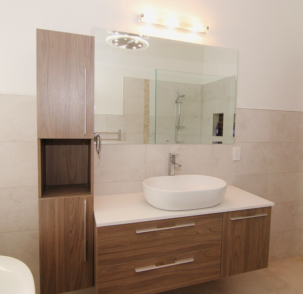 Inspiration for a mid-sized contemporary master bathroom in Auckland with a vessel sink, medium wood cabinets, engineered quartz benchtops, a freestanding tub, an open shower, beige tile, beige walls and porcelain floors.