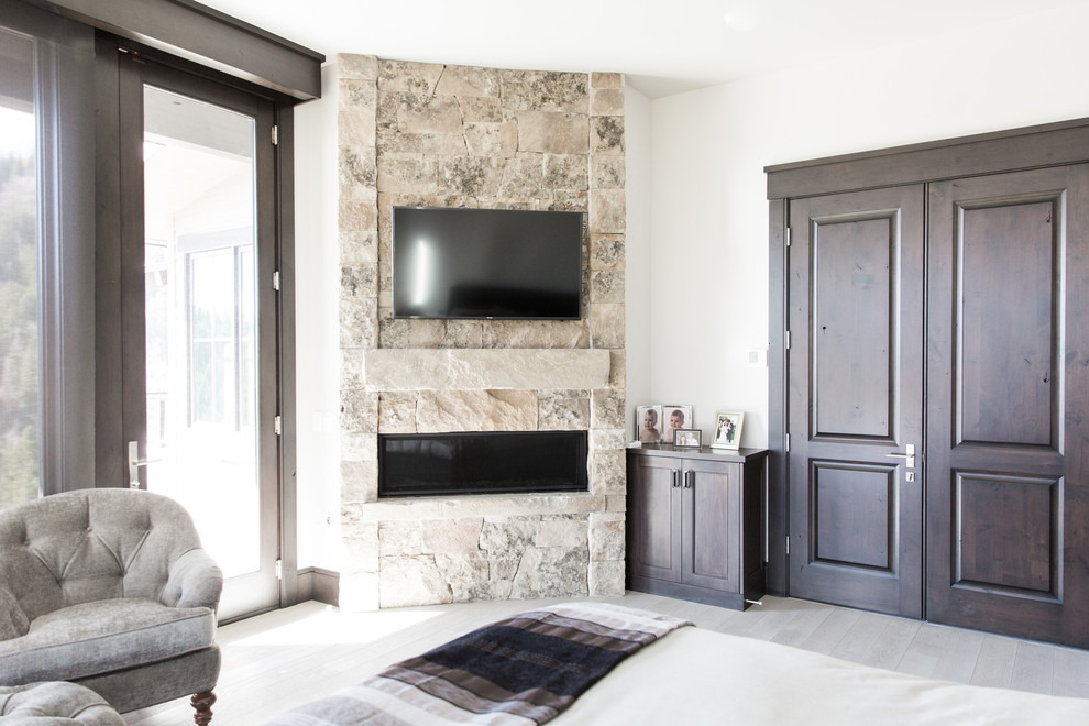 Источник вдохновения для домашнего уюта: спальня в стиле неоклассика (современная классика) с белыми стенами, стандартным камином, фасадом камина из каменной кладки и бежевым полом