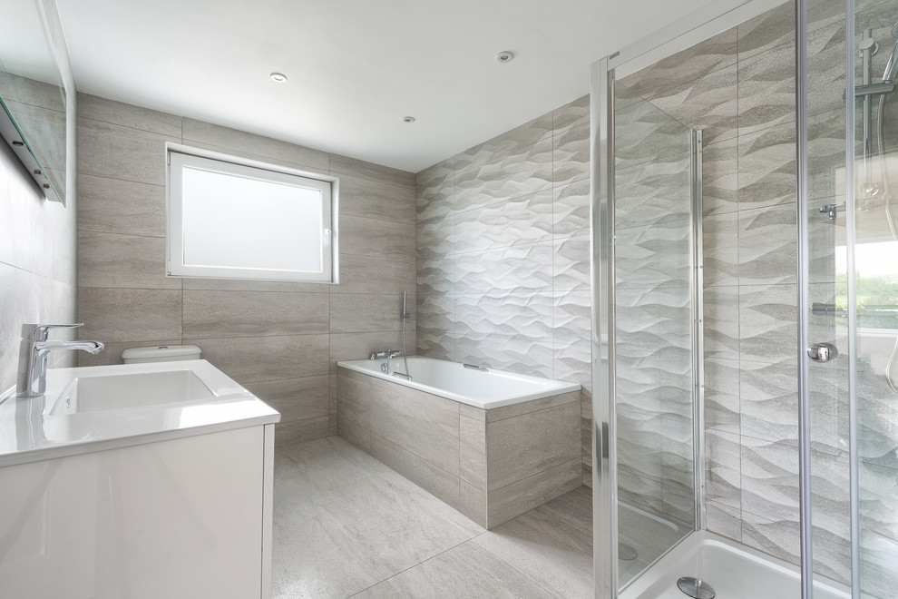 Large contemporary master bathroom in Devon with an integrated sink, flat-panel cabinets, white cabinets, engineered quartz benchtops, a drop-in tub, a double shower, a one-piece toilet, gray tile, ceramic tile and ceramic floors.