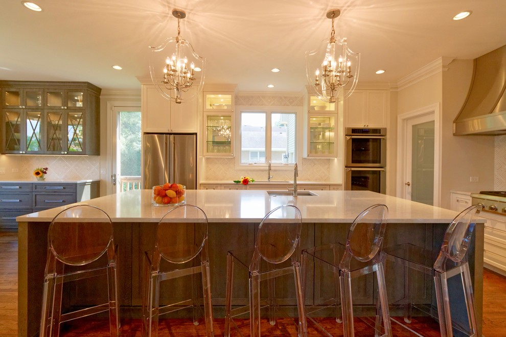 Large transitional l-shaped medium tone wood floor and brown floor eat-in kitchen photo in Chicago with an undermount sink, shaker cabinets, white cabinets, quartz countertops, white backsplash, mosaic tile backsplash, stainless steel appliances, an island and white countertops