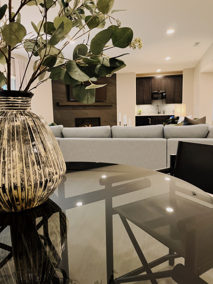 Large minimalist walk-out vinyl floor and beige floor basement photo with a bar, beige walls, a corner fireplace and a tile fireplace