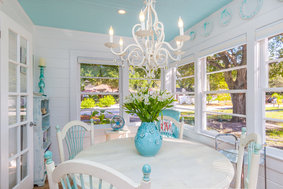 Example of a small beach style medium tone wood floor dining room design in Tampa with white walls