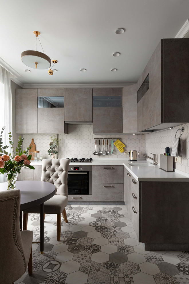 Design ideas for a mid-sized contemporary l-shaped eat-in kitchen in Moscow with an integrated sink, flat-panel cabinets, grey cabinets, white splashback, stainless steel appliances, ceramic floors, grey floor and white benchtop.