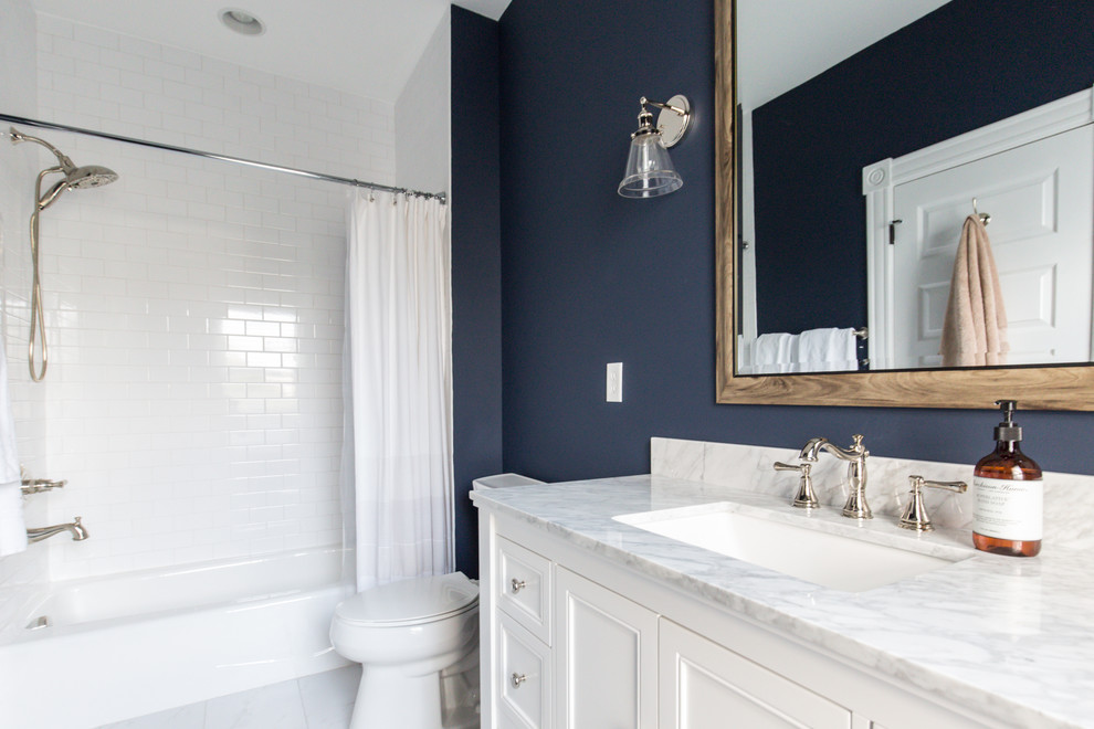 Traditional kids bathroom in Richmond with shaker cabinets, white cabinets, a drop-in tub, a two-piece toilet, white tile, subway tile, blue walls, ceramic floors, an undermount sink, marble benchtops and white floor.