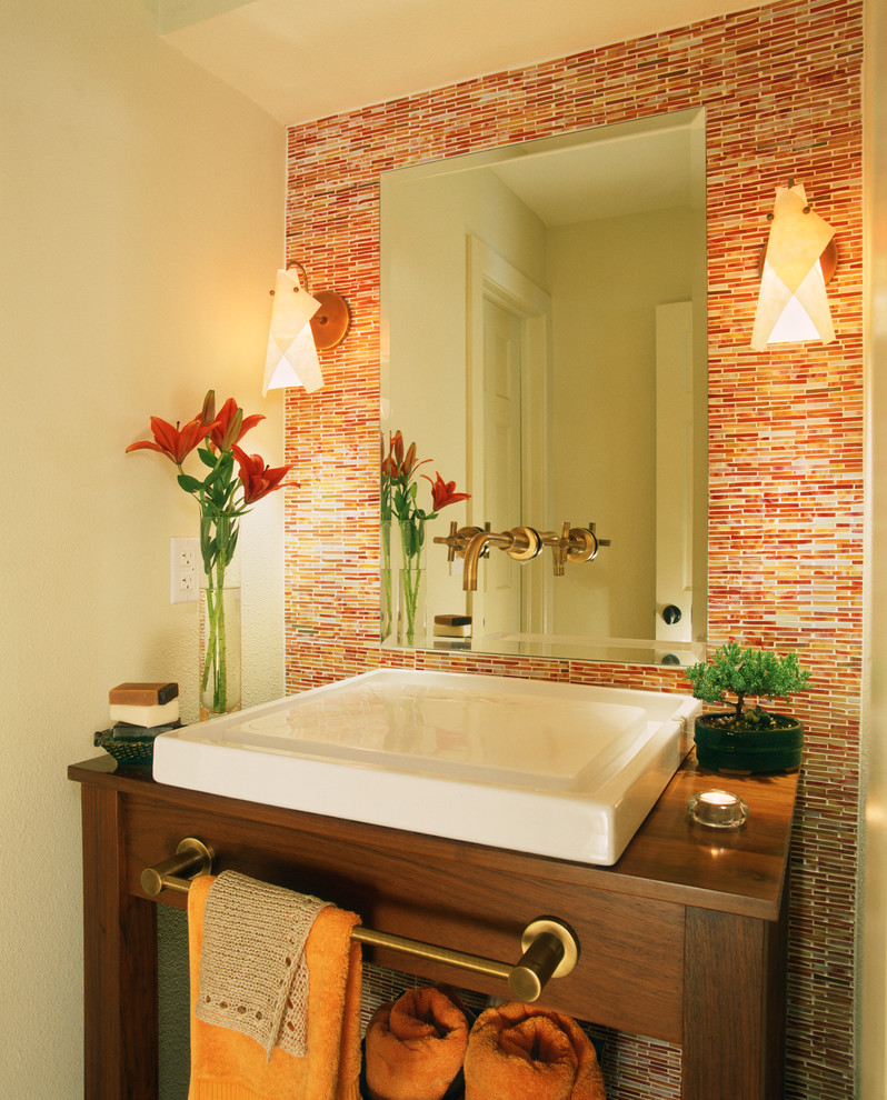 Inspiration for a small contemporary powder room in Denver with a vessel sink, furniture-like cabinets, dark wood cabinets, wood benchtops, orange walls, orange tile and brown benchtops.