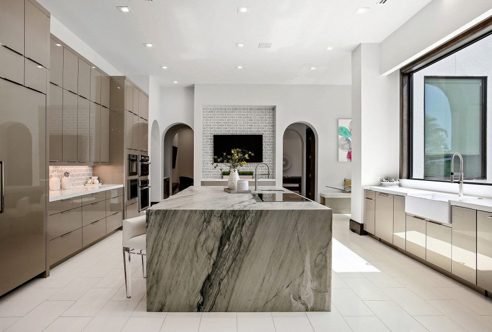 Contemporary u-shaped eat-in kitchen in Houston with a farmhouse sink, flat-panel cabinets, beige cabinets, grey splashback, panelled appliances, with island, white floor and multi-coloured benchtop.