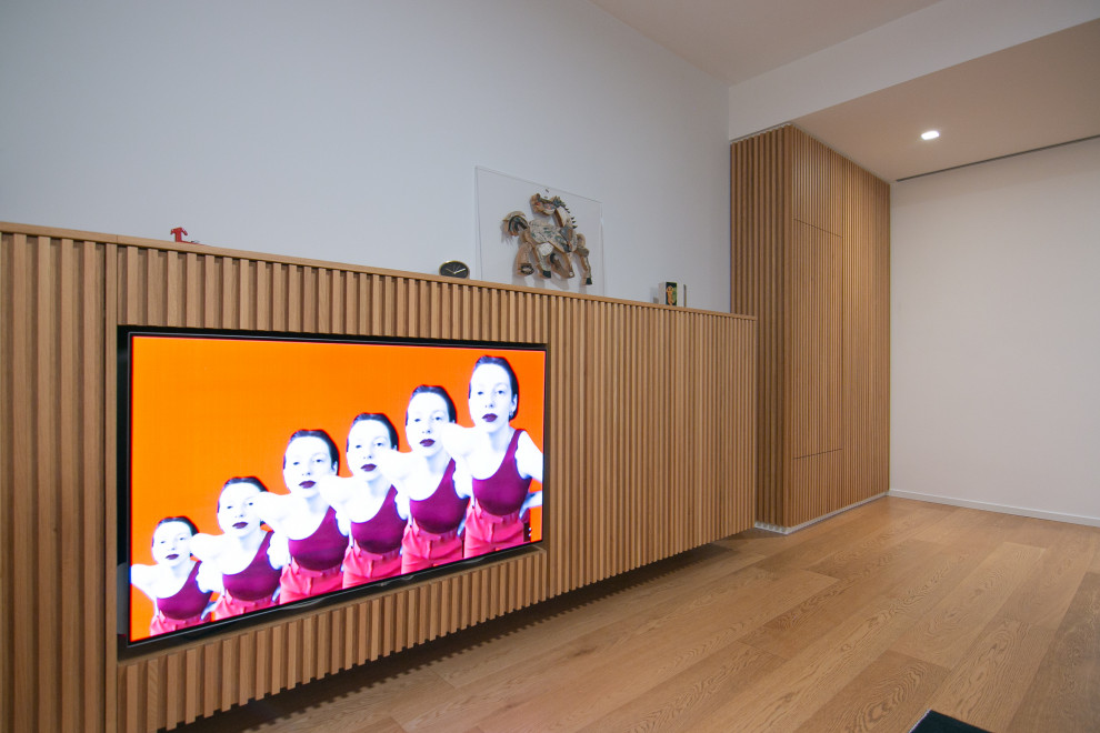 Diseño de salón abierto actual pequeño con suelo de madera en tonos medios, pared multimedia, bandeja y madera