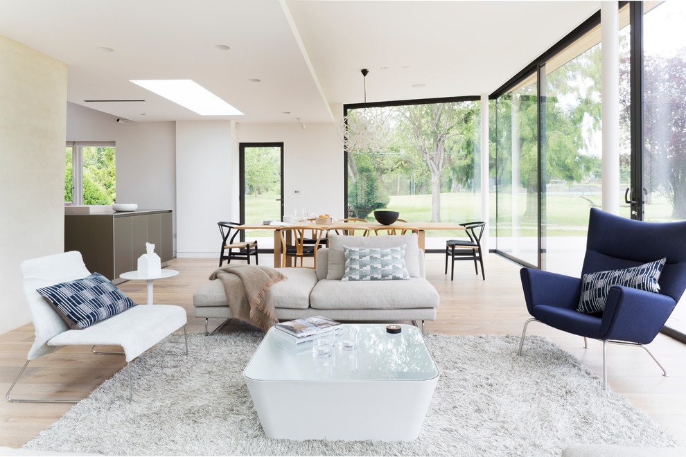 Design ideas for a modern living room in London with light hardwood floors.