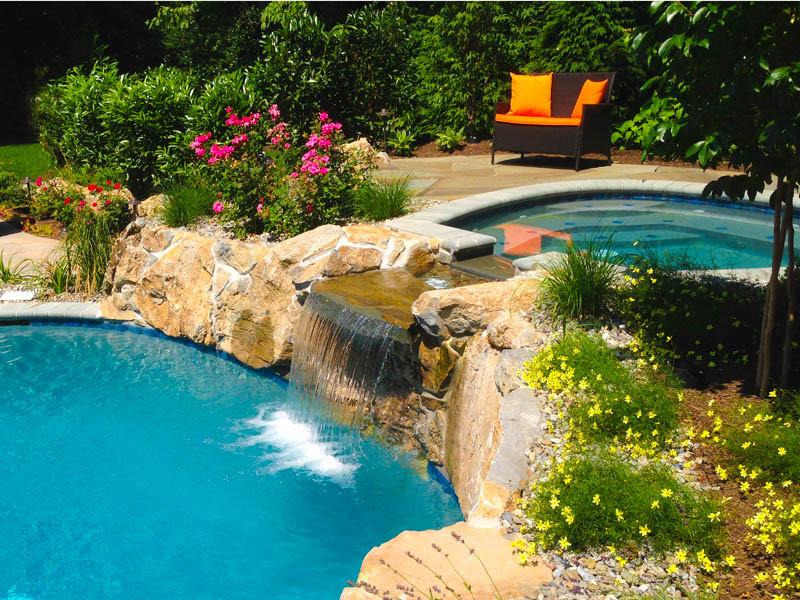 Hot tub - mid-sized transitional backyard stone and custom-shaped hot tub idea in New York