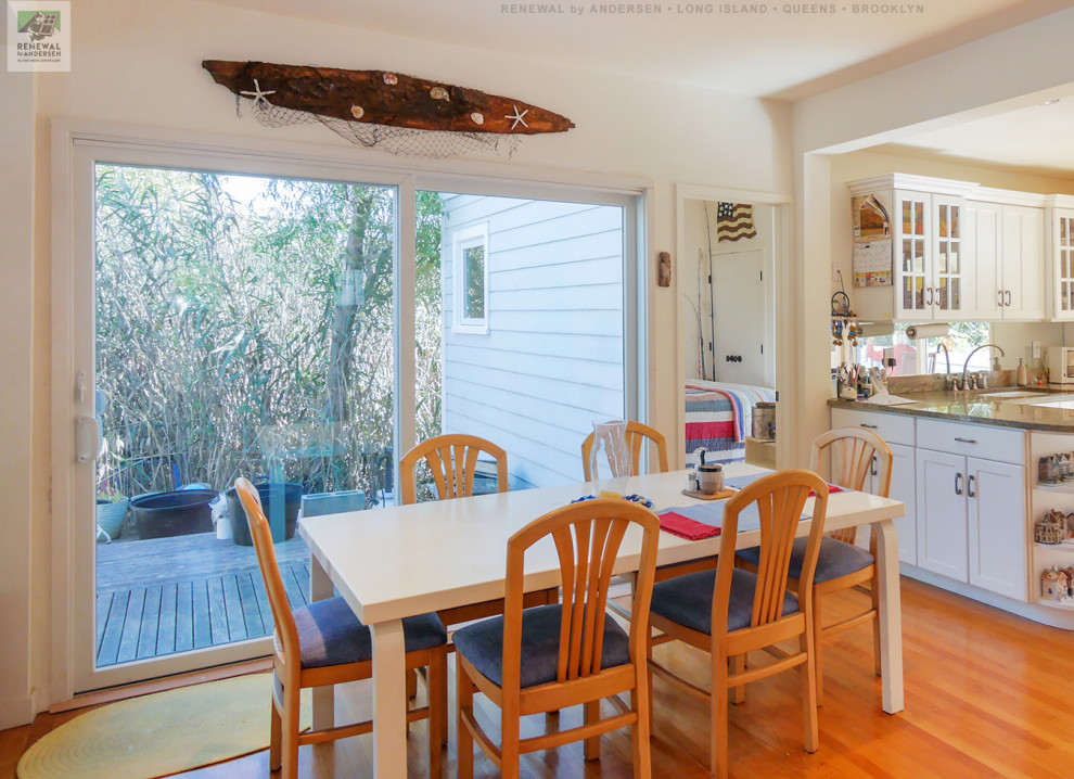 Photo of a mid-sized kitchen/dining combo in New York with white walls, light hardwood floors and vaulted.