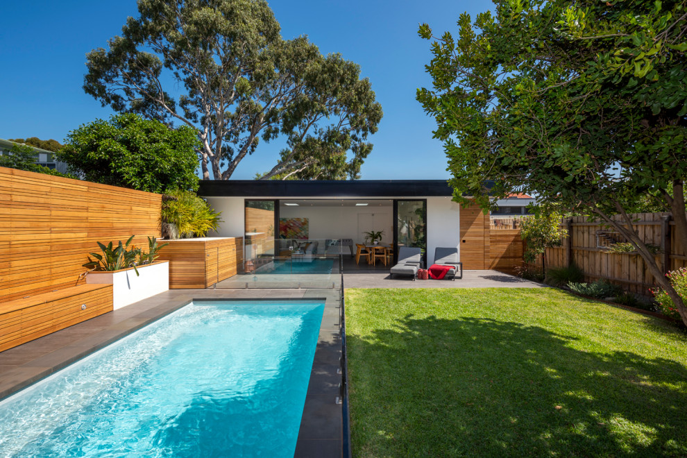 Photo of a mid-sized contemporary backyard partial sun garden in Melbourne with a vertical garden and natural stone pavers.
