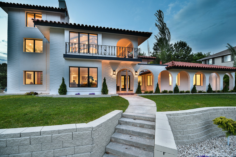 Photo of a large modern three-storey brick white house exterior in Salt Lake City with a hip roof and a tile roof.