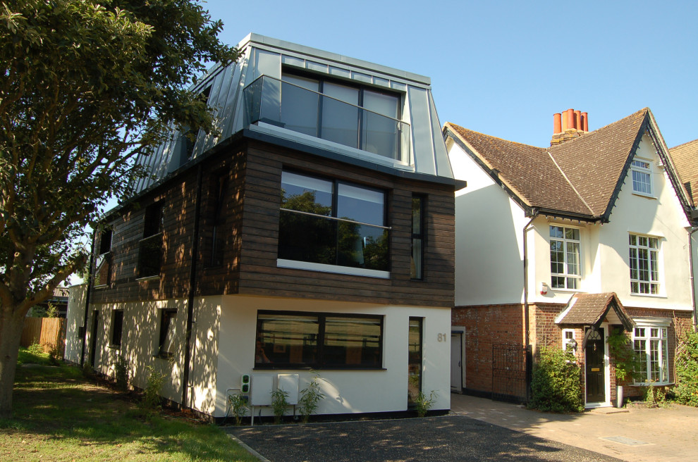 Modelo de fachada de casa beige y gris contemporánea grande de tres plantas con revestimiento de madera, tejado a doble faldón, tejado de metal y panel y listón
