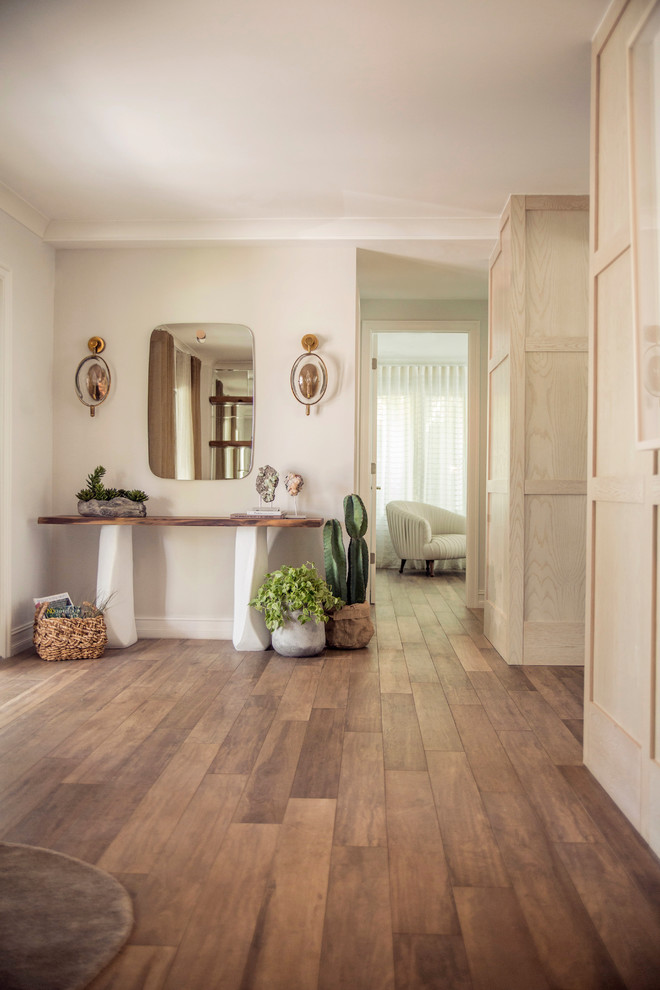 Inspiration for a mid-sized scandinavian hallway in Miami with porcelain floors, brown floor and white walls.