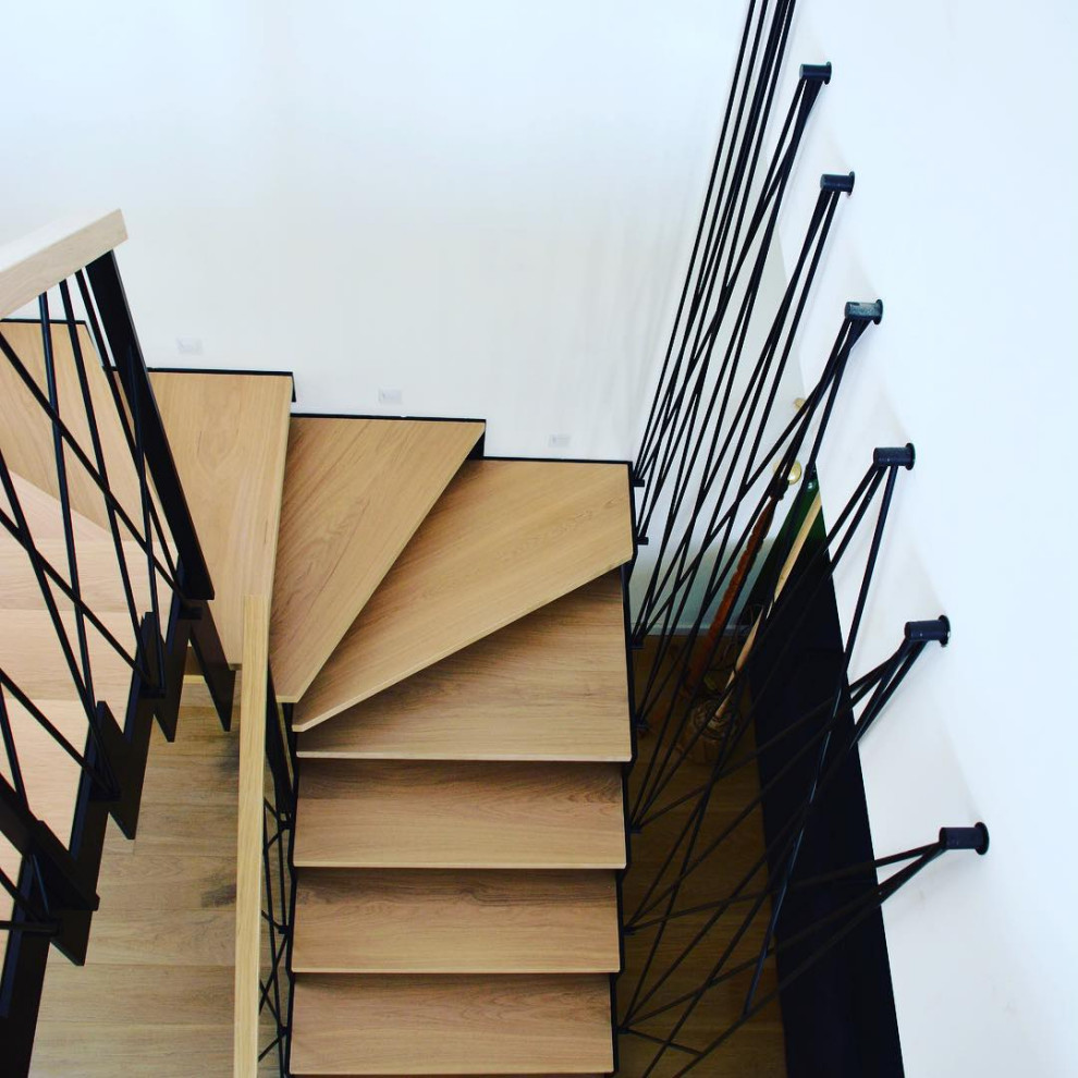 Photo of a medium sized industrial wood u-shaped wire cable railing staircase in Moscow with wood risers.