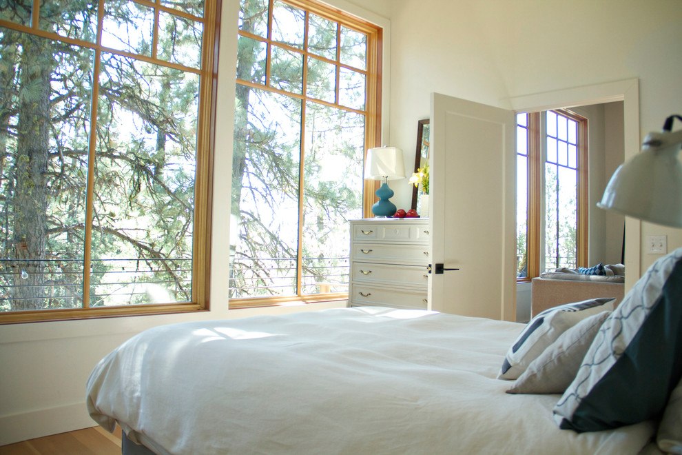 Mid-sized modern guest bedroom in Seattle with light hardwood floors, white walls, no fireplace and brown floor.