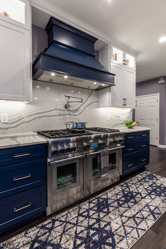 Foto di una cucina contemporanea di medie dimensioni con ante con riquadro incassato, ante blu, top in marmo, paraspruzzi bianco, elettrodomestici in acciaio inossidabile, pavimento in legno massello medio, pavimento grigio e top bianco