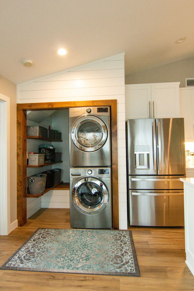 Design ideas for a country laundry cupboard in Seattle with a stacked washer and dryer and planked wall panelling.