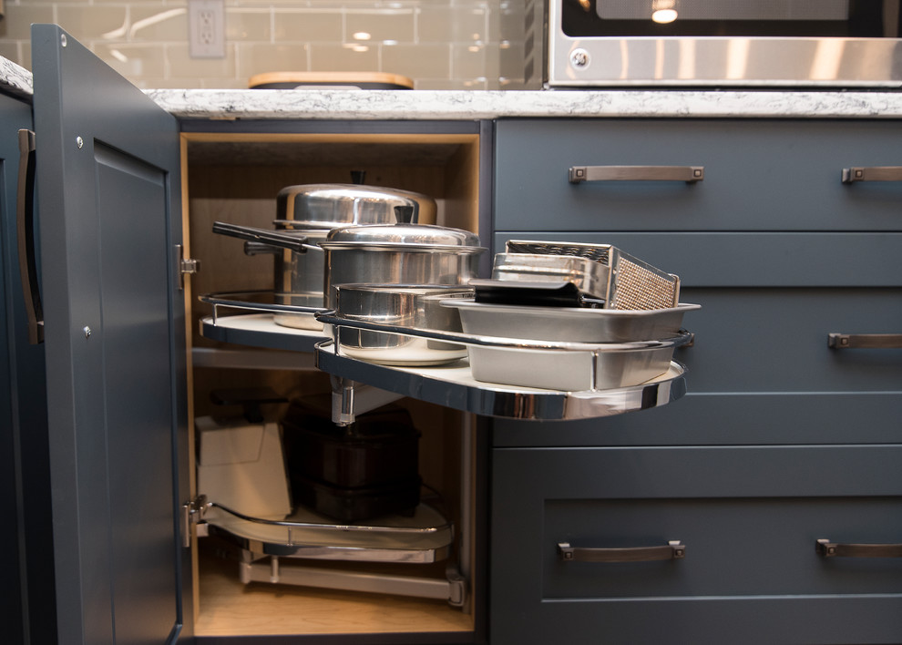 Example of a mid-sized transitional l-shaped brown floor eat-in kitchen design in Baltimore with a single-bowl sink, shaker cabinets, gray cabinets, quartz countertops, gray backsplash, subway tile backsplash, stainless steel appliances, an island and white countertops