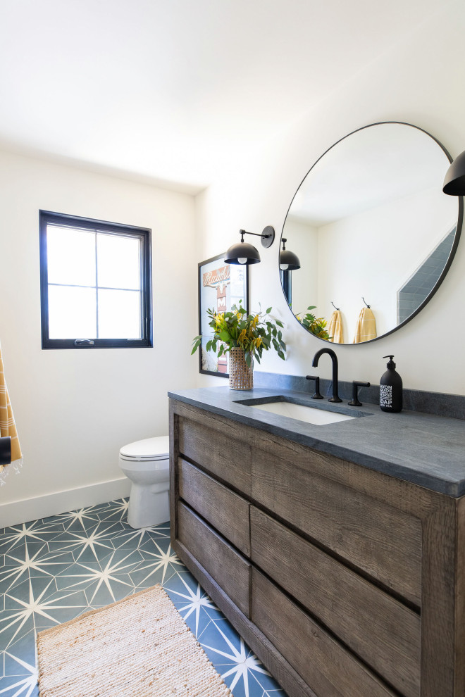 Photo of a country bathroom in San Francisco with flat-panel cabinets, dark wood cabinets, white walls, an undermount sink, blue floor and grey benchtops.