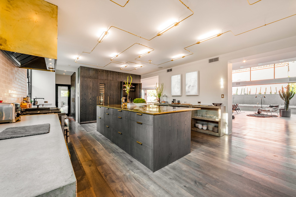 This is an example of an expansive contemporary single-wall eat-in kitchen in Los Angeles with white splashback, with island, flat-panel cabinets, concrete benchtops, grey cabinets, grey floor, medium hardwood floors and subway tile splashback.