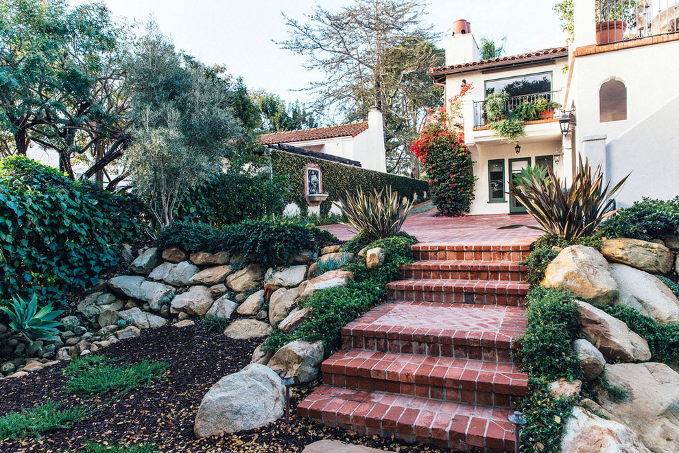 Photo of a mid-sized mediterranean backyard full sun driveway in Santa Barbara with brick pavers.