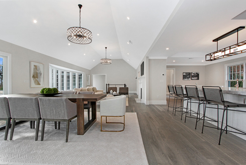 Immagine di una grande sala da pranzo aperta verso il soggiorno design con pareti bianche, pavimento in legno massello medio, pavimento marrone e soffitto a volta