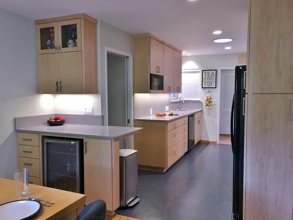 Photo of a small modern galley eat-in kitchen in San Francisco with an undermount sink, flat-panel cabinets, light wood cabinets, quartz benchtops, grey splashback, black appliances, linoleum floors and no island.