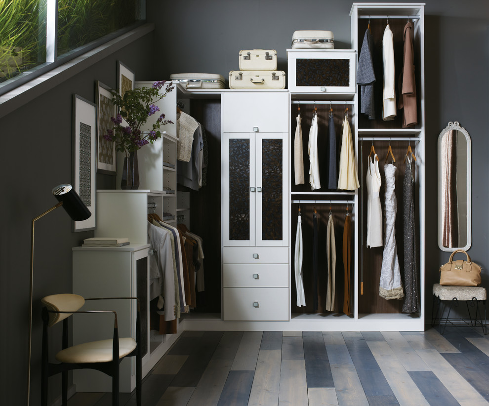 Design ideas for a large modern gender-neutral dressing room in Orlando with flat-panel cabinets, white cabinets, vinyl floors and brown floor.