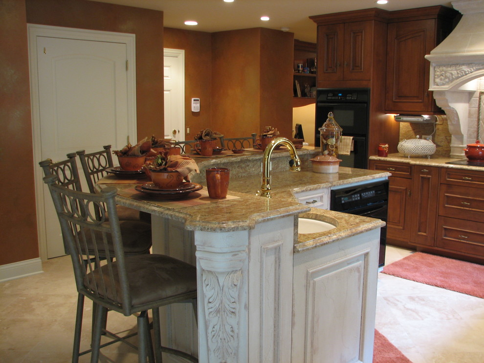 Photo of a mediterranean l-shaped eat-in kitchen in Chicago with a farmhouse sink, beaded inset cabinets, medium wood cabinets, marble benchtops, beige splashback, stone tile splashback, panelled appliances, limestone floors and with island.