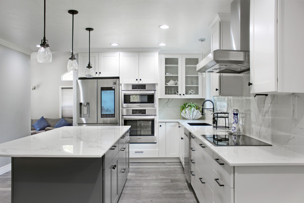 Example of a large trendy l-shaped vinyl floor and gray floor eat-in kitchen design in Other with an undermount sink, shaker cabinets, white cabinets, quartz countertops, white backsplash, quartz backsplash, stainless steel appliances, an island and white countertops