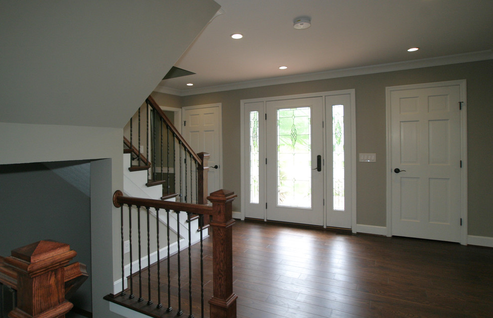 Inspiration for an expansive transitional foyer in Cincinnati with a single front door, a white front door, grey walls and medium hardwood floors.