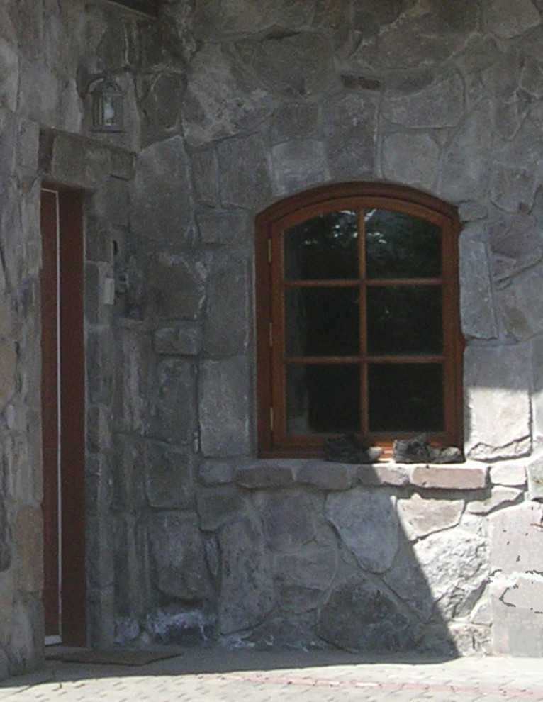 Inspiration for a large country three-storey grey house exterior in Vancouver with stone veneer and a gambrel roof.