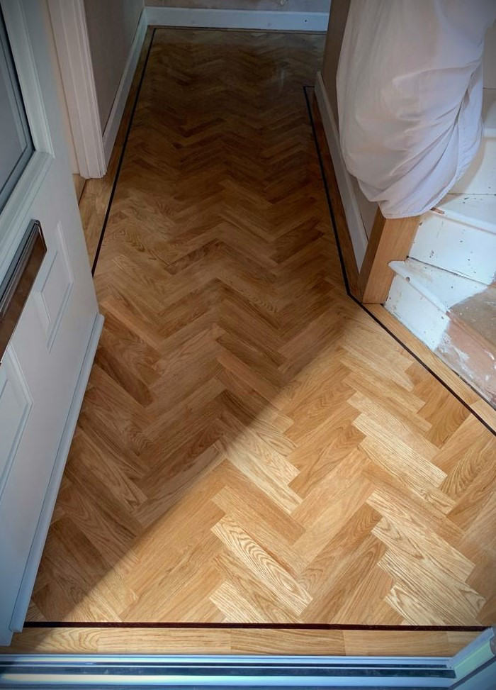 Immagine di un grande ingresso o corridoio classico con pavimento in legno massello medio e pavimento marrone