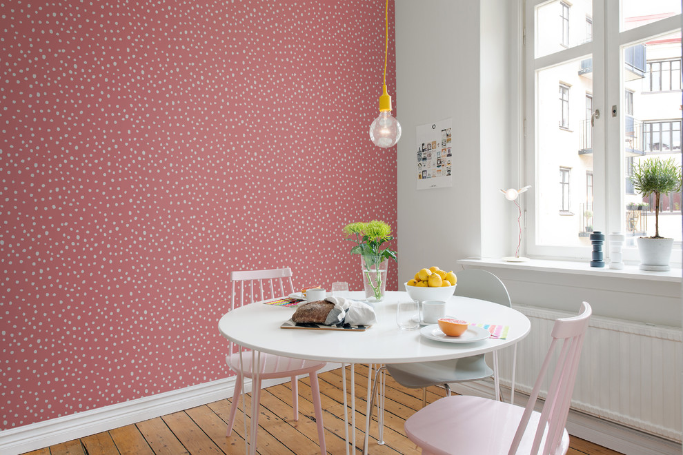 Photo of a small scandinavian separate dining room in Gothenburg with pink walls, light hardwood floors and beige floor.