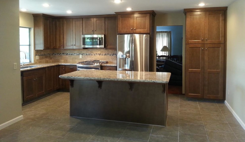 Inspiration for a mid-sized transitional l-shaped ceramic tile and brown floor kitchen remodel with an undermount sink, shaker cabinets, medium tone wood cabinets, granite countertops, beige backsplash, subway tile backsplash, stainless steel appliances and an island