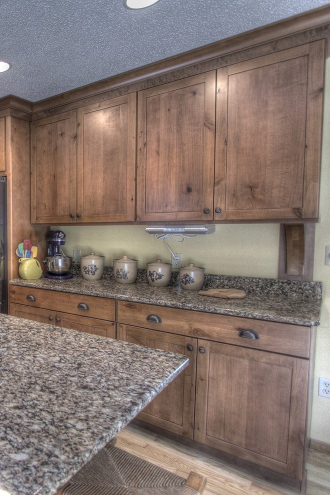 Inspiration for a rustic u-shaped eat-in kitchen remodel with an undermount sink, shaker cabinets, medium tone wood cabinets, quartz countertops and black appliances