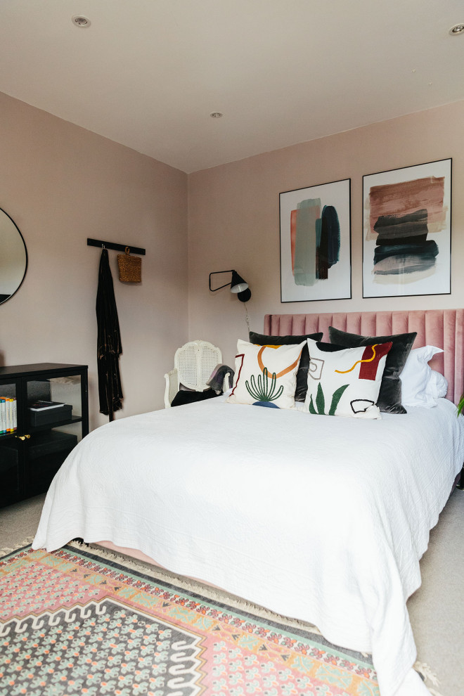 На фото: гостевая спальня среднего размера, (комната для гостей) в стиле модернизм с розовыми стенами, ковровым покрытием, стандартным камином, бежевым полом и кирпичными стенами