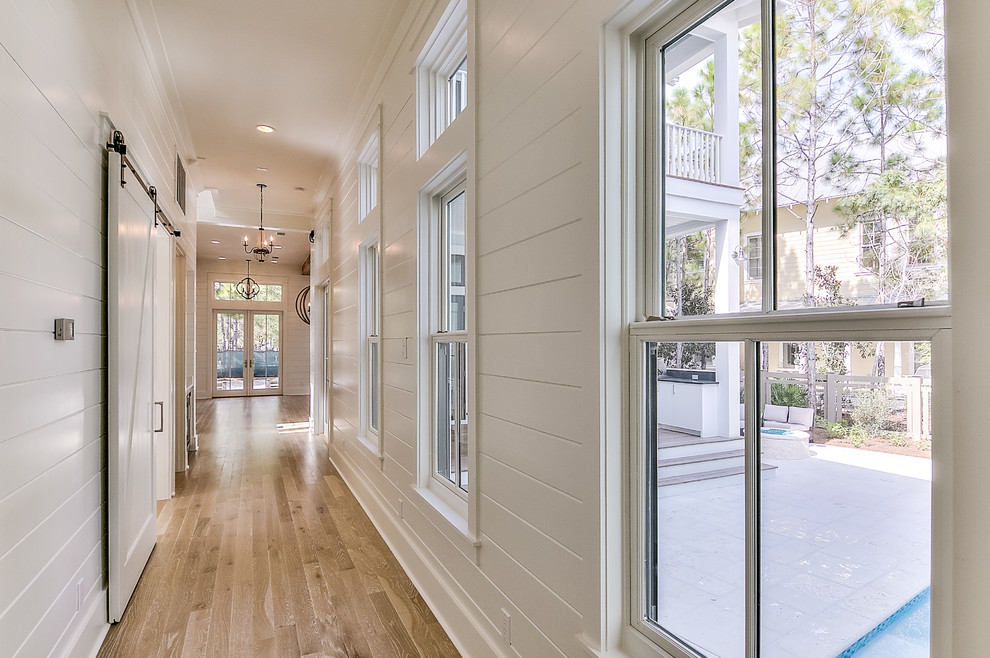 Large beach style hallway in Other with white walls and painted wood floors.