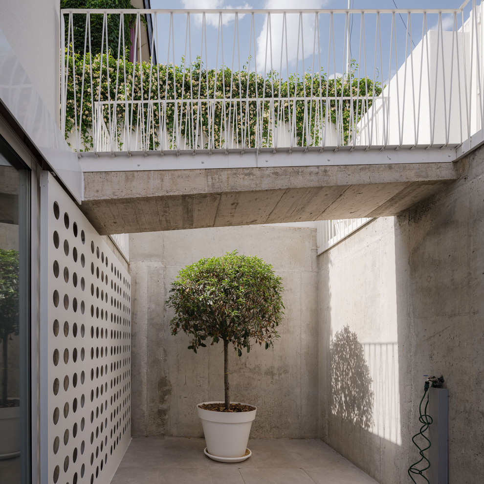 Foto de patio contemporáneo de tamaño medio sin cubierta en patio delantero con losas de hormigón