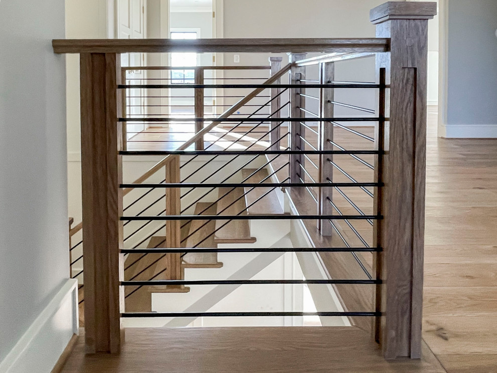 На фото: большая деревянная лестница на больцах в стиле ретро с деревянными ступенями и перилами из смешанных материалов с